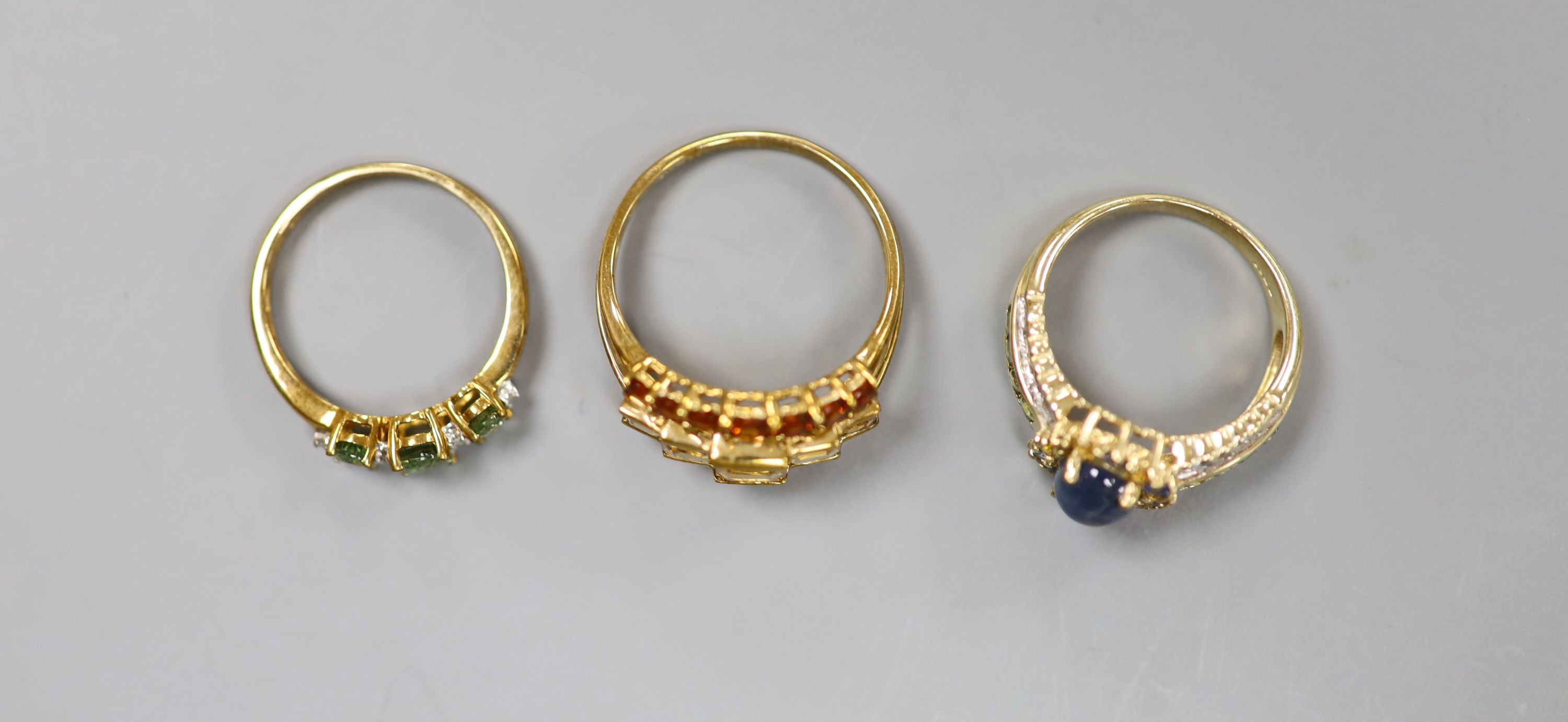 A 9ct gold cabochon sapphire and diamond ring and two other 9ct gold gem-set rings